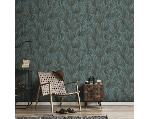 Vardagsrum med mönstrad tapet, fåtölj och sidobord