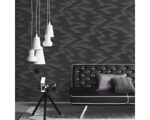 Rums vy med mönstrad tapet, soffa, bord och hängande lampor