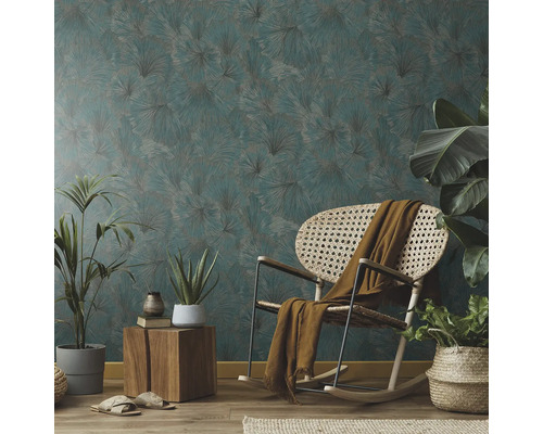 Vardagsrum med mönstrad tapet, gungstol och krukväxter