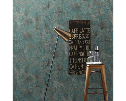 Miljöbild med mönstrad tapet, golvlampa, barstol, dryckeskaraff, glas och en skylt med kaffedrycker