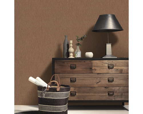 Scen med byrå, lampa, dekoration och mönstrad tapet