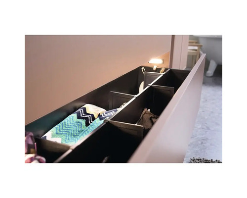 Öppet badrumsskåp med fack och handdukar.