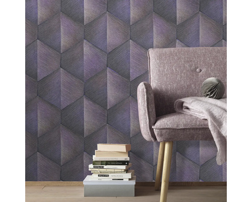 Rumsvy med grafisk tapet, fåtölj och bokstapel.