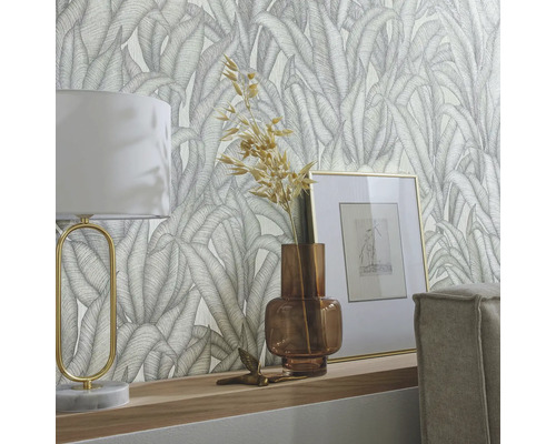 Dekorativ tapet med bladmönster i ett vardagsrum med lampa och dekoration