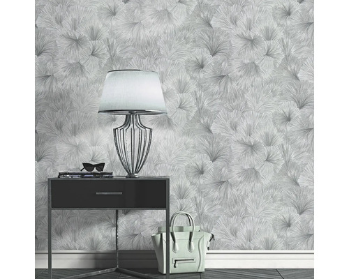 Miljöbild med mönstrad tapet, sängbord, lampa, handväska och accessoarer