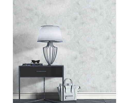 Ljust rum med mönstrad tapet, sängbord, lampa och handväska