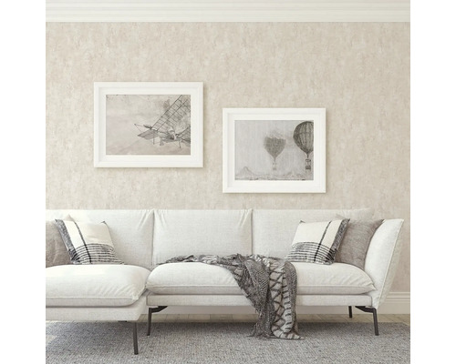 Vardagsrum med soffa, kuddar, filt och tavlor på väggen