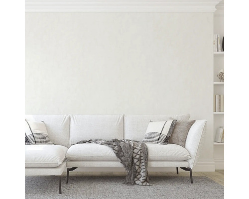 Vardagsrum med vit soffa, kuddar och bokhylla