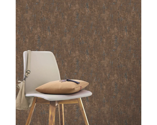 Inredningsexempel med brun tapet i bakgrunden, en stol och en väska