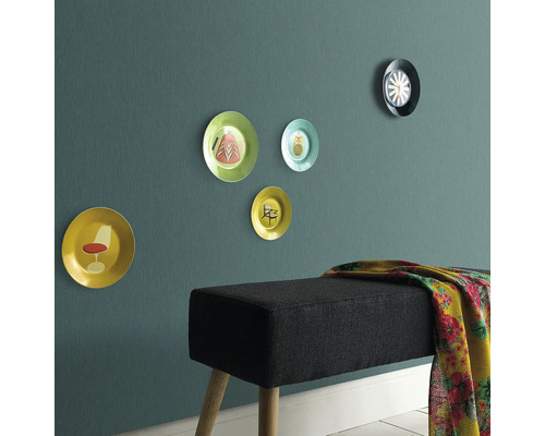 Väggdekoration med prydnadstallrikar och en bänk