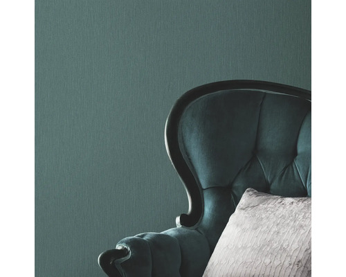 Närbild av en mönstrad tapet och en fåtölj med knappstoppning