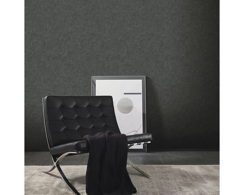 Vardagsrum med mörk vinyltapet, fåtölj och inramad bild