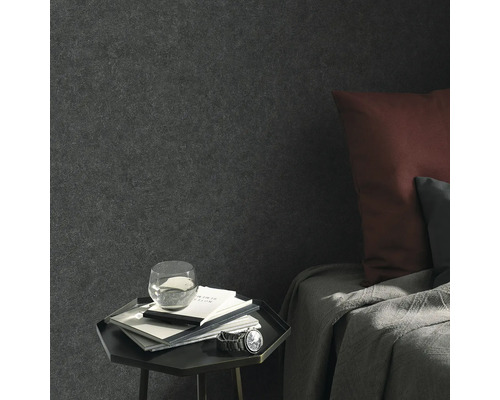 Vardagsrumsscen med textil tapet, sängbord, anteckningsböcker, glas vatten och armbandsur