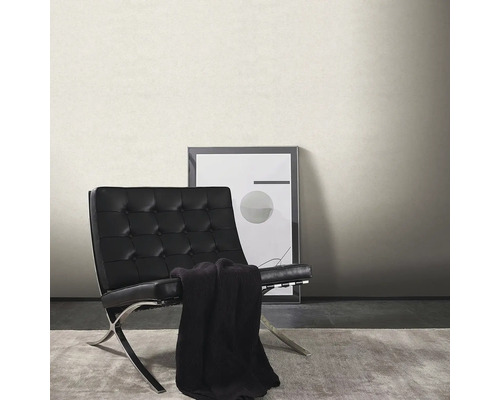 Vardagsrum med enfärgad tapet, fåtölj och bild