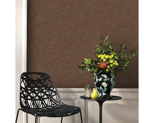 Vardagsrum med brun tapet, stol och blomsterarrangemang på ett bord