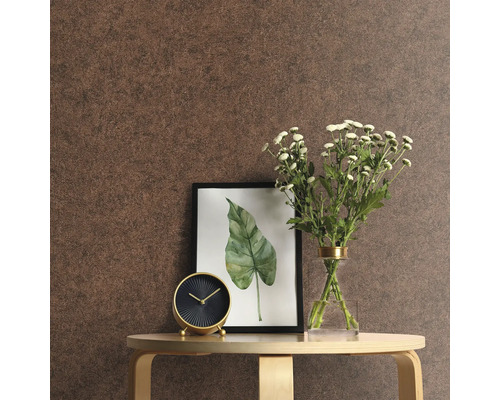 Närbild av ett rum med brun tapet, bord, klocka, blommor och en inramad bild