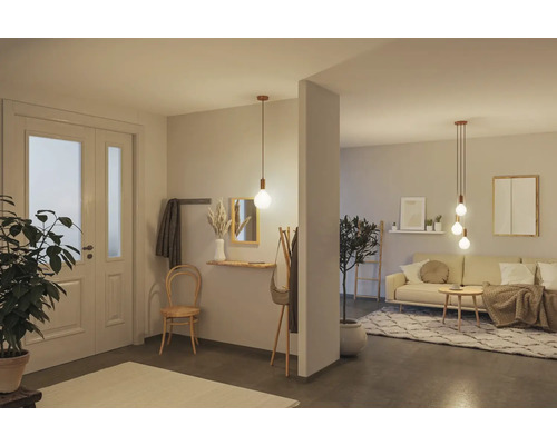 Ljus interiör med pendellampor, möbler och dekorationer i hall och vardagsrum.