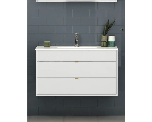 Badrum med tvättställsskåp med två lådor och armatur framför en kakelvägg