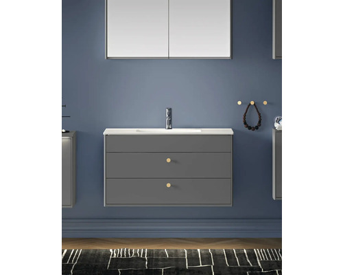 Modernt badrum med grått tvättställsskåp, spegel och tillbehör