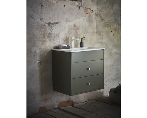 Hängande tvättställsskåp med tre lådor, tvättställ, armatur och dekoration framför en vägg.