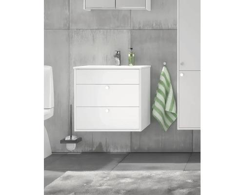 Badrum med vitt tvättställsskåp, handduk och toalett