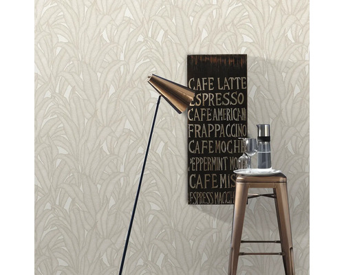 Scen med tapet med bladmönster, golvlampa, barstol, dryckkaraff, glas och kaffetavla