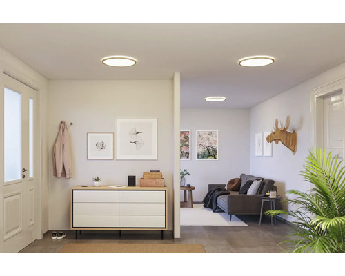 Interiör med taklampor, byrå och soffa för en ljus, vänlig atmosfär.