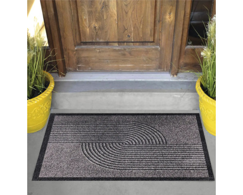 Dörrmatta med halvcirkelmönster framför en ytterdörr