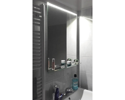 Badrum med belyst spegel och tvättställ