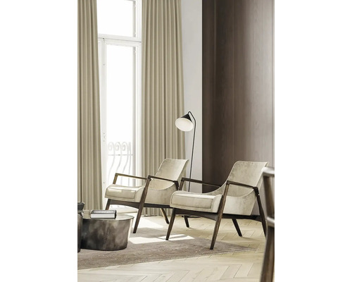 Vardagsrum med två fåtöljer, golvlampa och gardiner