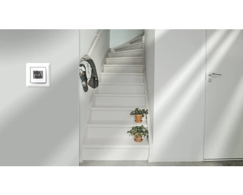 Rumsöversikt med temperaturregulator på väggen, trappa och dörr