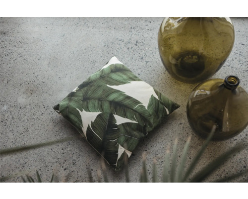 Dekorativ kudde med bladmönster och glasvaser