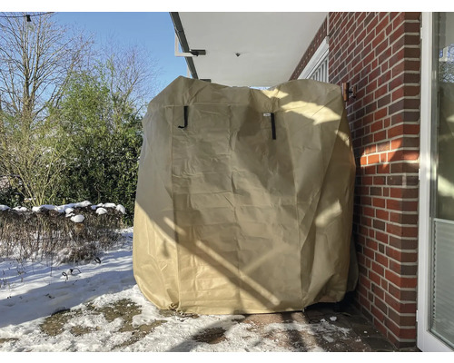 Övertäckt trädgårdsgrill med skyddshölje i vinterträdgården.