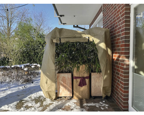 Vinterlandskap med planteringskärl och vinterskyddshuva för växter