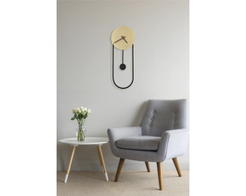 Vardagsrum med pendelur, fåtölj och bord med blommor