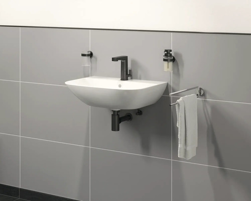 Vägghängd tvättställ med blandare, tvålpump, tandborstmugg och handdukshållare i badrummet.