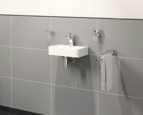 Ljust badrum med rektangulärt handfat, armatur, handdukshållare, tvålpump och tandborstmugg