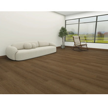 Vardagsrum med soffa, krukväxt, gungstol och trägolv