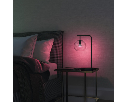 Sovrum med säng, nattduksbord och bordslampa med glaskupa