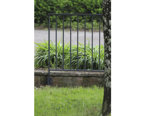 Metallstaket på en stenmur i trädgården