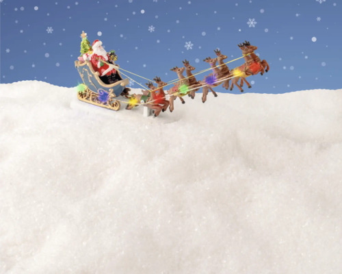 Juldekoration med jultomten i en släde dragen av renar