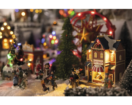 Julby scen med figurer, träd, karusell och presentbutik