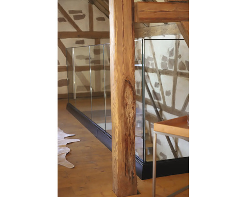 Interiör av ett rum med glasräcke och träbjälkar