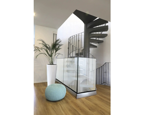 Interiör med spiraltrappa, växt och sittpuff