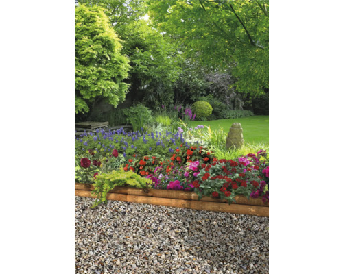 Trädgård med blommor, grus och träkant