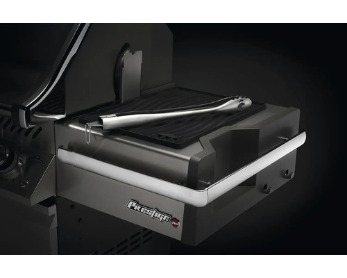 Detaljvy av en grill med grilltång på värmehyllan