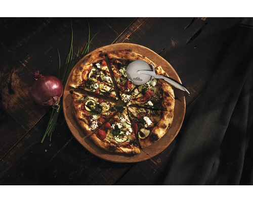 Pizza på träbräda med pizzaskärare, lök och gräslök