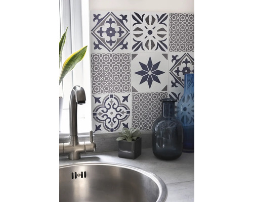 Diskho med blandare framför en vägg med dekorativa plattor i ett kök.