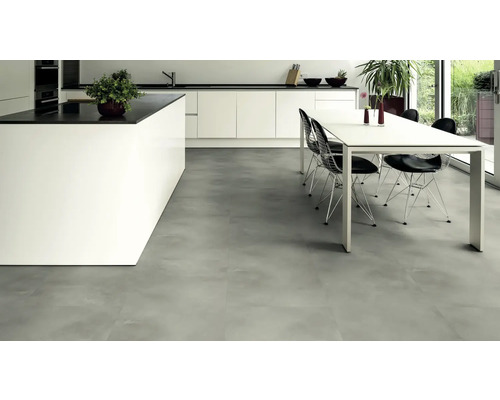 Ljust kök med köksö, matbord och golvplattor i betonglook