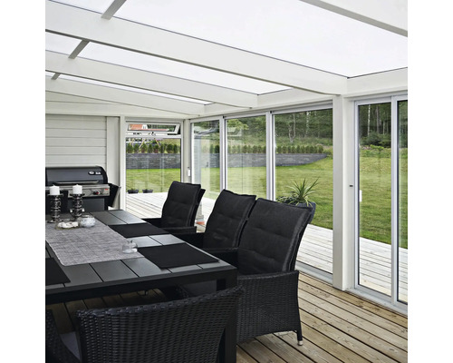 Veranda med utemöbler, grill och utsikt över trädgården.